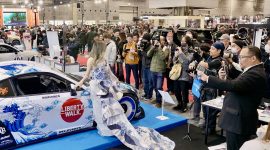 Booth NMAA Great of Indonesia menjadi pusat perhatian di Osaka Auto Messe 2026, Jepang. Toyota 86 “Harmony of Waves” tampil memukau dengan livery bernuansa ombak dipadukan gaun batik karya desainer Indonesia, saat dikelilingi fotografer dan pengunjung yang mengabadikan momen.