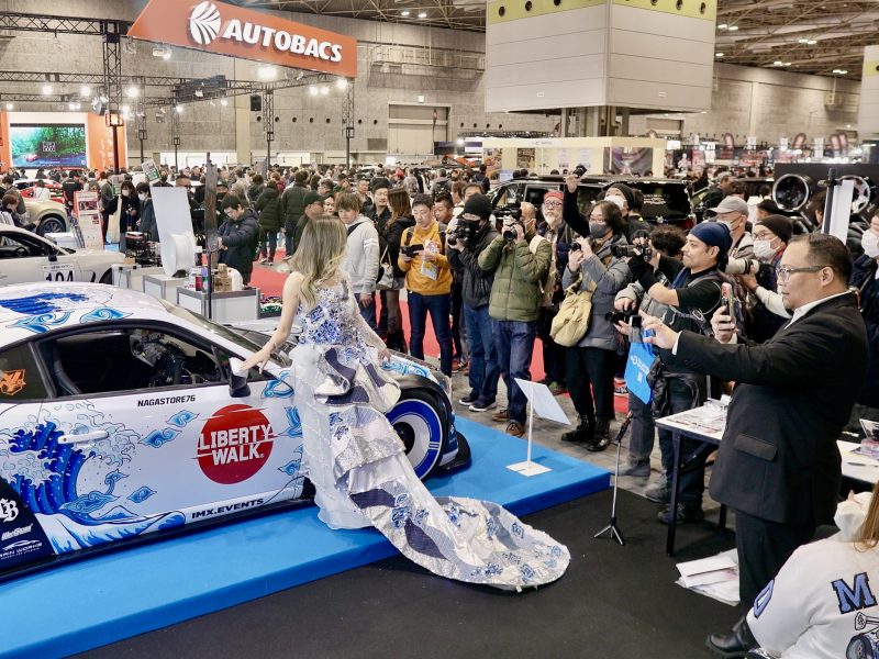 Booth NMAA Great of Indonesia menjadi pusat perhatian di Osaka Auto Messe 2026, Jepang. Toyota 86 “Harmony of Waves” tampil memukau dengan livery bernuansa ombak dipadukan gaun batik karya desainer Indonesia, saat dikelilingi fotografer dan pengunjung yang mengabadikan momen.