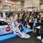 Booth NMAA Great of Indonesia menjadi pusat perhatian di Osaka Auto Messe 2026, Jepang. Toyota 86 “Harmony of Waves” tampil memukau dengan livery bernuansa ombak dipadukan gaun batik karya desainer Indonesia, saat dikelilingi fotografer dan pengunjung yang mengabadikan momen.