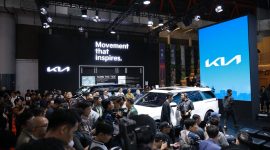 Booth Kia dipadati pengunjung dalam sebuah pameran otomotif, menampilkan lini kendaraan terbaru dengan slogan “Movement that inspires.”