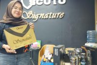 Dewi Ruwiyatul Lailiyah, Outlet Head Scuto Signature Cibitung, menunjukkan paket Signature Coating di outlet yang berlokasi di Jalan Raya Teuku Umar No. 44A, Kabupaten Bekasi, Senin (2/3/2026). Menjelang Ramadan, layanan nano ceramic coating dan proteksi kendaraan menjadi favorit pelanggan untuk menjaga tampilan mobil tetap kinclong dan terlindungi.