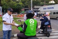 Ketua White Car Indonesia (WCI) Regional Betawi, Daeng Syahruddin membagikan paket takjil kepada pengemudi ojek online di kawasan Pintu 1 Teater Keong Mas TMII, Jakarta, dalam kegiatan berbagi takjil kepada masyarakat yang masih beraktivitas di jalan menjelang waktu berbuka puasa pada Ramadan 2026.