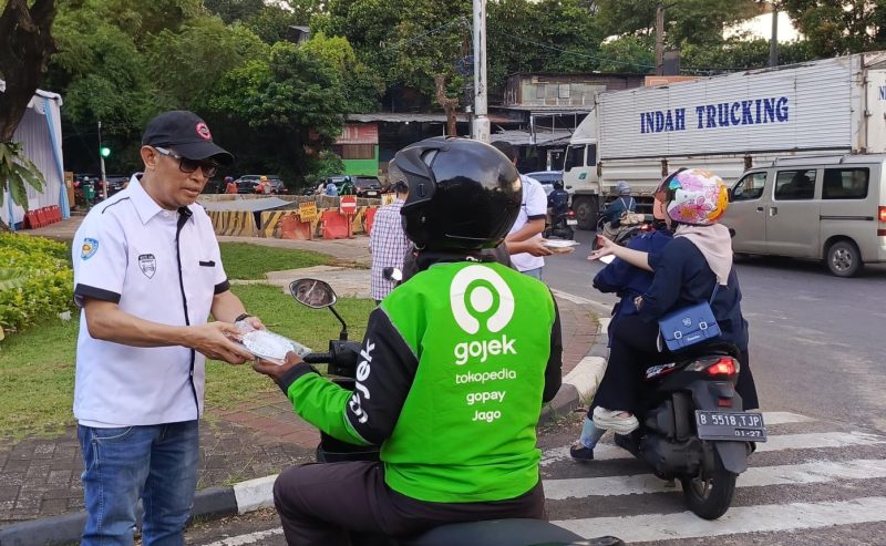 Ketua White Car Indonesia (WCI) Regional Betawi, Daeng Syahruddin membagikan paket takjil kepada pengemudi ojek online di kawasan Pintu 1 Teater Keong Mas TMII, Jakarta, dalam kegiatan berbagi takjil kepada masyarakat yang masih beraktivitas di jalan menjelang waktu berbuka puasa pada Ramadan 2026.