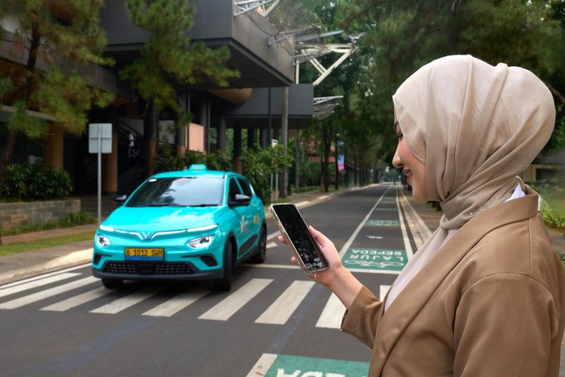Ilustrasi pengguna memesan layanan kendaraan listrik melalui aplikasi Green SM di kawasan perkotaan. Green SM mencatat pertumbuhan signifikan di Asia-Pasifik dan meraih predikat Best EV Carpooling App dalam ajang Sensor Tower APAC Awards 2025.