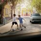 Dua anak bermain sepak bola di jalan lingkungan dengan latar mobil Hyundai Motor Company, sementara robot humanoid dari Boston Dynamics terlihat berinteraksi di sisi jalan, menggambarkan kolaborasi teknologi dan semangat FIFA World Cup 2026.