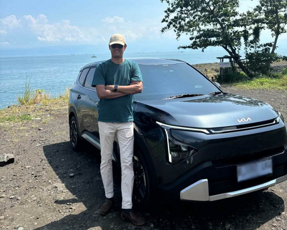 Pengguna The all-new Carens, Chidlir (42), berfoto bersama kendaraan miliknya saat perjalanan keluarga di kawasan pesisir Ciletuh, Sukabumi. Dalam dua bulan penggunaan, mobil ini telah menempuh lebih dari 2.000 kilometer di berbagai kondisi jalan.