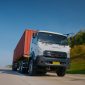 Isuzu GIGA mengangkut kontainer melaju di jalan tol, menjadi salah satu kendaraan komersial yang mendukung aktivitas logistik dan distribusi barang di Indonesia.