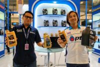Direktur PT Sumber Suwarna Unisindo, Hannes Chang (kiri), bersama perwakilan PTT Lubricants menunjukkan produk pelumas dalam ajang Indonesia Modification & Lifestyle Expo (IMX) 2026. PTT Lubricants memperkenalkan teknologi EVOTEC yang diklaim mampu meningkatkan efisiensi bahan bakar dan perlindungan mesin. (Foto: Dok. PTT Lubricants)