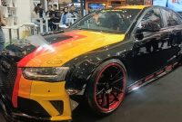 Keterangan Foto: Mobil modifikasi berbalut warna Obsidian Black dengan kombinasi grafis kuning, oranye, dan merah tampil di booth Penta Prima Paint pada ajang IMX 2026 di Tangerang. Finishing hitam mengilap dipadukan dengan velg sporty beraksen merah, memperkuat karakter agresif kendaraan.